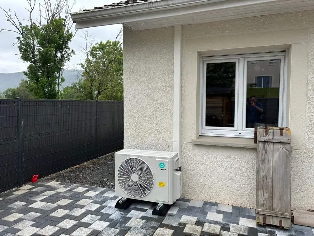 Unité extérieure de climatisation installée en façade au-dessus d'une terrasse